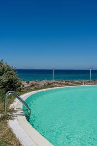 una piscina con vista sull'oceano sullo sfondo di Bellevue Sardinia Resort, Affiliated by Meliá a Valledoria