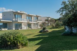 un grande condominio con un cortile verde di Bellevue Sardinia Resort, Affiliated by Meliá a Valledoria