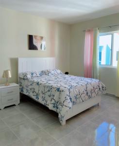 1 dormitorio con cama y ventana en Sunset Home 2B (Gated), en Higüey