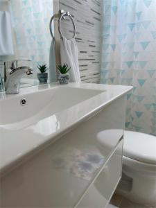 Baño blanco con lavabo y aseo en Sunset Home 2B (Gated) en Higuey