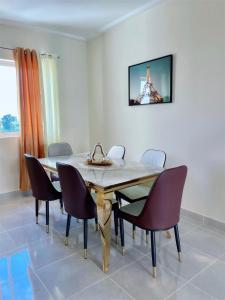 a dining room table with chairs and the eiffel tower at Sunset Home 2B (Gated) in Higuey