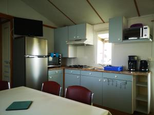Angles的住宿－Mobile Home La Tranche sur Mer 6 personnes，厨房配有冰箱和桌椅