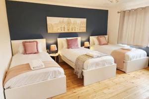 オックスフォードにあるParadigm Villa, Oxford,4 Bedroom, 4 Free Parking Spacesのベッドルーム1室(ピンクの枕が付くベッド2台付)