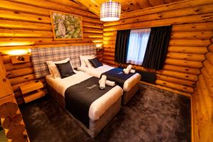a bedroom with two beds in a log cabin at Kare Luxury Chalets in Tsigov Chark