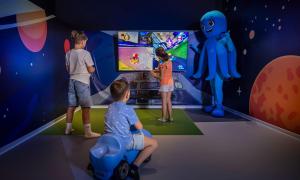 a group of children playing a video game in a room at Aminess Vival Maestral Hotel in Novigrad Istria