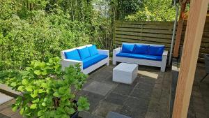 two blue chairs and a table on a patio at Cappuccetto Rosso in Nieuwe-Niedorp