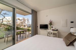 Bellevue Sardinia Resort, Affiliated by Meliá في فاليدوريا: غرفة نوم بسرير وشرفة