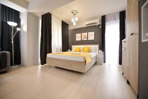 een slaapkamer met een bed met gele kussens bij Reina Apartments Skopje in Skopje
