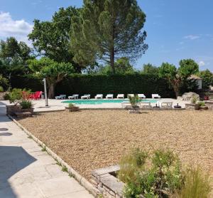 a swimming pool in a yard with chairs around it at Ardèche les cigales, studio murier piscine partagée in Grospierres