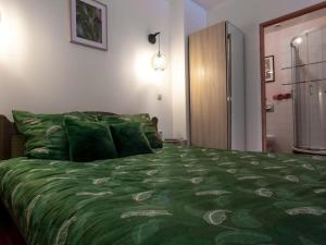 a bedroom with a bed with a green comforter at KAMYKÓWKA apartament w sąsiedztwie gór i lasów in Piechowice