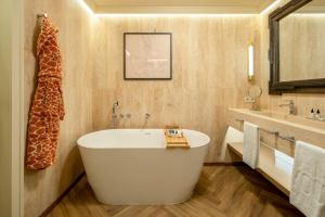 a bathroom with a large tub and a sink at Only YOU Hotel Sevilla in Seville