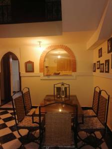 a dining room with a table and chairs and a mirror at Riad Hicham in Marrakesh