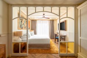 Habitación de hotel con cama con dosel y escritorio. en Only YOU Hotel Sevilla en Sevilla