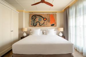 a bedroom with a white bed and a ceiling fan at Only YOU Hotel Sevilla in Seville