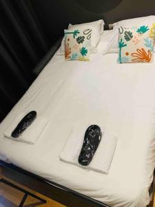 a bed with two remote controls and towels on it at Le Petit Lyonnais - Coeur de Lyon - 2 pers. in Lyon