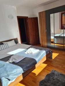 a bedroom with a large bed and a mirror at Вила Мариам Villa Mariam in Batak