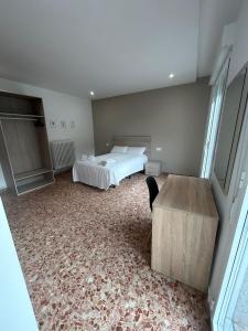 a bedroom with a bed and a desk in it at Pensión Arnedo in Arnedo