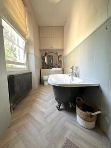 a bathroom with a tub and a sink and a toilet at Hillside in Bristol