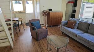 een woonkamer met een bank en een tafel bij Cappuccetto Rosso in Nieuwe-Niedorp