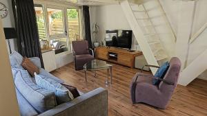 uma sala de estar com dois sofás e uma televisão em Cappuccetto Rosso em Nieuwe-Niedorp