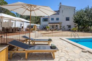 un patio con 2 sillas y una sombrilla junto a la piscina en Mas Tinus - Lavanda, en Santa Cristina d'Aro