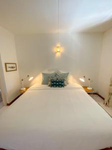 - un grand lit blanc dans une chambre avec deux lampes dans l'établissement *New* Chic Home with Private Pool, 1 min to Beach, à Cap Malheureux