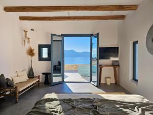 sypialnia z łóżkiem i widokiem na ocean w obiekcie Lefki Sokolata w Koufonisii