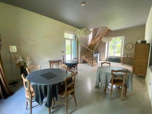 a dining room with a table and chairs and a staircase at Domaine de La Soudelle in Chanceaux-sur-Choisille