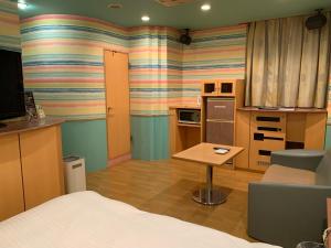 仙台市にあるホテル　るテラスⅡのベッド、テーブル、キッチンが備わる客室です。