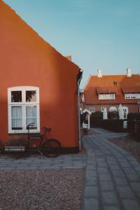 a bike parked next to a orange building at Brøndums Hotel in Skagen