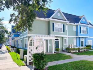 a large blue house with a lawn in front of it at Sunshine Retreat 4 Bed Town Home-4017VBD in Kissimmee