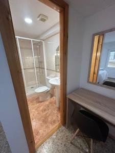 a bathroom with a sink and a toilet and a mirror at Pensión Arnedo in Arnedo