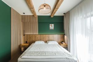 オラデアにあるStokker Hotelの緑の壁のベッドルーム1室(大型ベッド1台付)