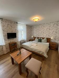 - une chambre avec un grand lit et une table dans l'établissement Penzion U Křížku, à Malá Morávka