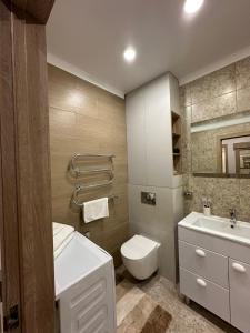 een badkamer met een wit toilet en een wastafel bij Уютная, новая квартира в центре города in Qostanaj