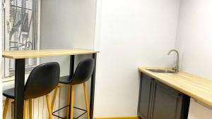 a kitchen with a counter and a chair next to a sink at Uneed Rooms M1 in Kyiv