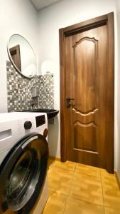 a washing machine in a bathroom with a door at Uneed Rooms M1 in Kyiv
