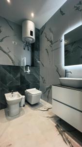 uma casa de banho com um lavatório, um WC e um lavatório. em Loft Office 2 em Castel Maggiore