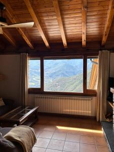 a living room with a large window with a mountain view at Casa Jonico in Montardit