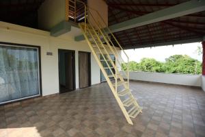 een houten ladder in een kamer met een groot raam bij Gokarna villa Tondavali in Achra