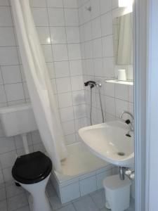 uma casa de banho com um WC preto e um lavatório. em Bauernhof-Pension Puschnikhof em Unternarrach