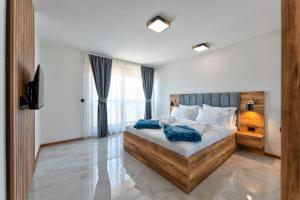 a bedroom with a large bed with blue pillows at Golden Panorama Spa & Wellness in Zlatibor