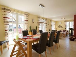 a dining room with a wooden table and chairs at Villa Harmony in Glowe