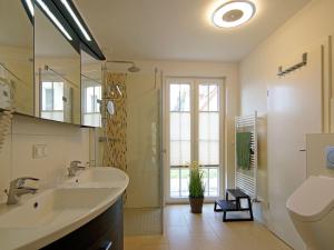 a bathroom with a sink and a shower and a toilet at Villa Harmony in Glowe