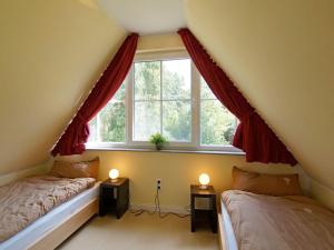 a attic bedroom with two beds and a window at Villa Harmony in Glowe +14 photos