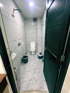 Green leaf Hotel في اوجاين: حمام صغير مع مرحاض ومغسلة