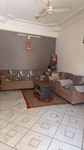 Sala de estar con 2 sofás y mesa en Abu Banglow, en Mount Abu