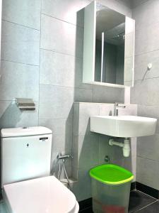 een badkamer met een wit toilet en een wastafel bij J&H JESSELTON QUAY lSLAND TRIP in Kota Kinabalu