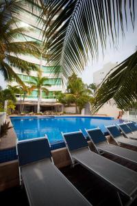 a row of chairs sitting next to a swimming pool at Banderas Suites in Bucerías