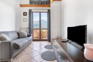a living room with a couch and a flat screen tv at Casa vacanze vigna del Lago in Dongo